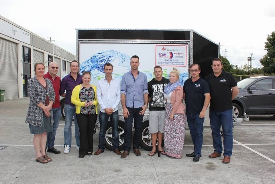 A group of Eco Boss regional distributors standing in front of the branded trailer on launch day