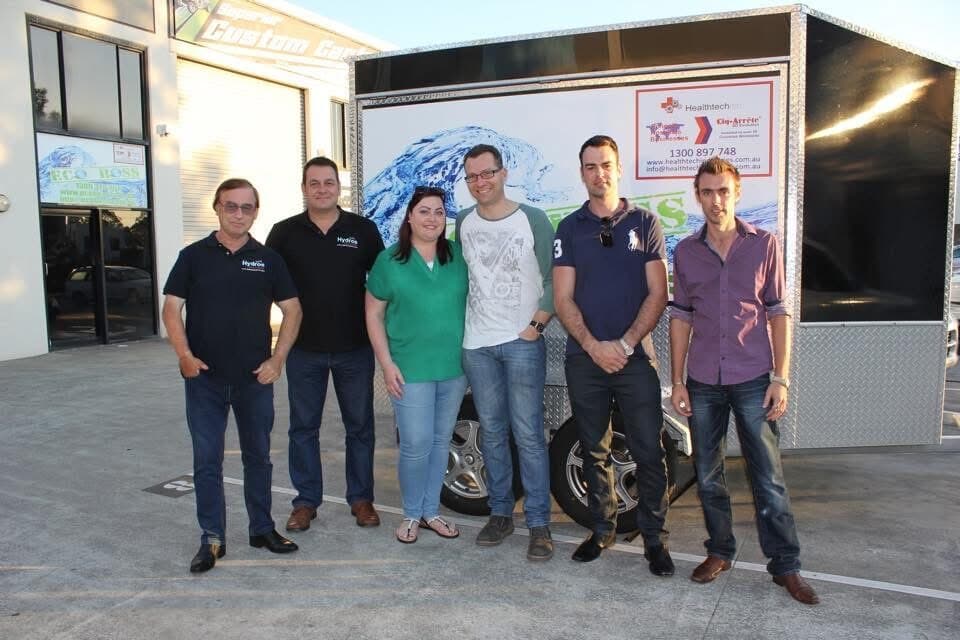 The Eco Boss team standing in front of a branded trailer outside a Gold Coast warehouse