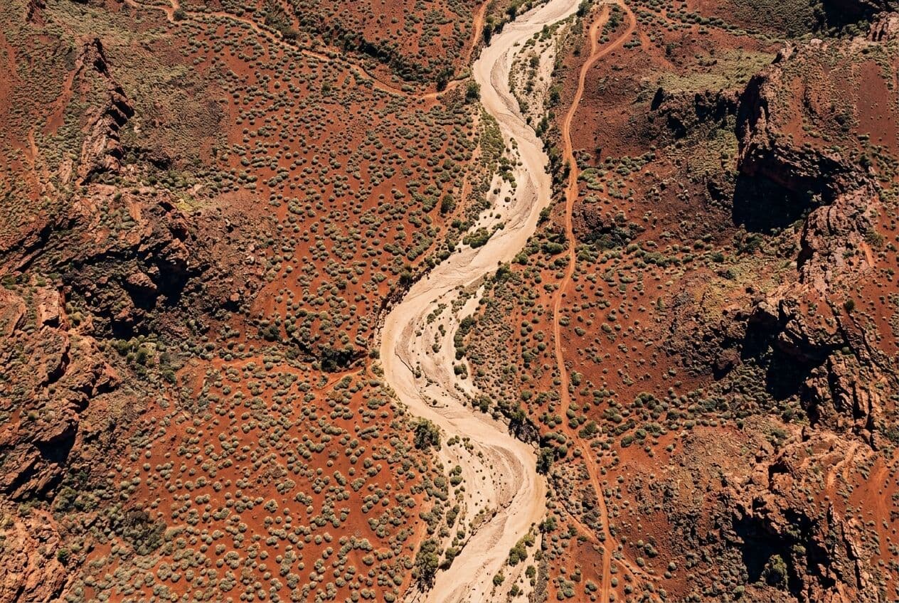 Aerial view of red Pilbara earth, spinifex and a dry riverbed